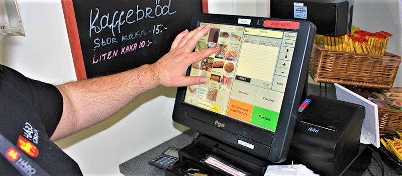 Arbetstagare på Café Håbo registrerar ett köp med hjälp av kassaapparaten.