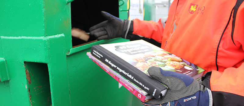 Arbetstagare återvinner böcker på återvinningscentralen.