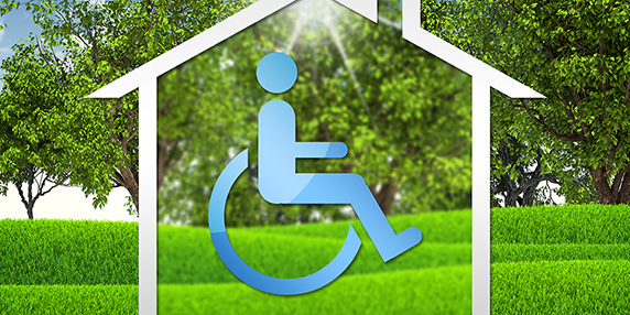 En rullstolssymbol i en symbol för ett hus, med gröna träd och gräs i bakgrunden