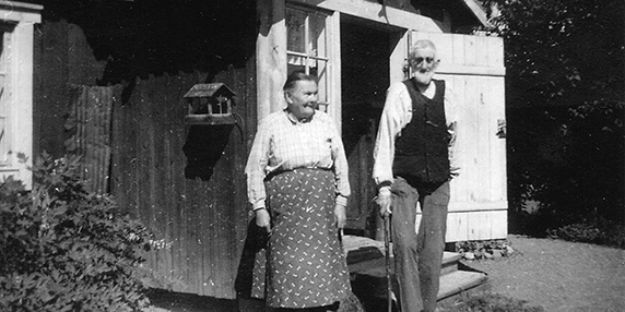 Ett svartvit fotografi på en man och en kvinna framför Soldattorpet