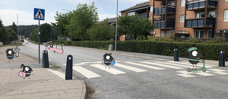 Övergångsställe i Håbo med små illustrerade figurer som åker sparkcykel och går med barnvagn