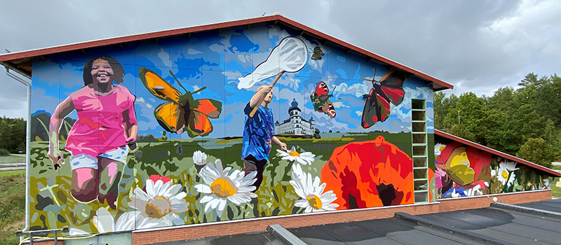 En väggmålning med barn och blommor
