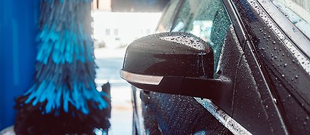 Biltvätt med borstar vatten och en bil