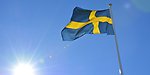Svenska flagga vajar i vinden i solsken